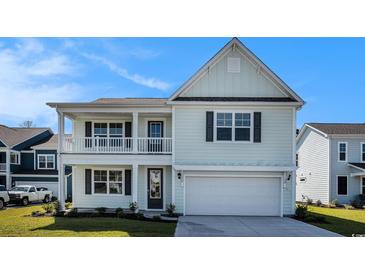 Charming two-story home featuring a light blue exterior, a covered front porch, and an attached garage at 727 Rupert Dr, Conway, SC 29526