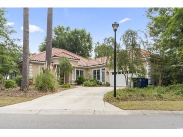 Charming single-story home with a red tile roof, mature landscaping, and a spacious driveway at 1501 Harbor Dr., North Myrtle Beach, SC 29582