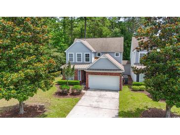 Charming two-story home with gray siding, brick accents, manicured landscaping, and a two-car garage at 1535 Harlow Ct., Myrtle Beach, SC 29579