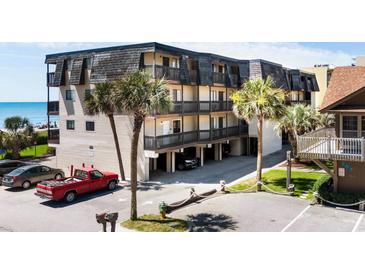 Coastal condo complex with covered parking, lush palms, and ocean views from private balconies at 201 76Th Ave. N # D-3, Myrtle Beach, SC 29572