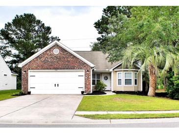 Charming single-story home with brick accents, a well-manicured lawn, and an attached two-car garage at 230 Vermillion Dr., Little River, SC 29566