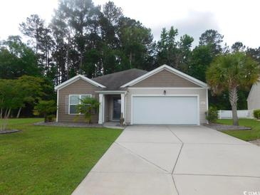 Charming single-story home with a well-maintained lawn, palm trees, and a two-car garage at 401 Quinta St., Longs, SC 29568