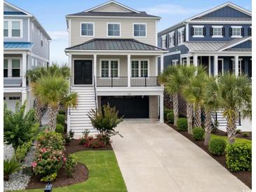 Two-story home featuring a 1-car garage, a manicured lawn, and lush landscaping, and a metal roof at 433 Saint Julian Ln., Myrtle Beach, SC 29579