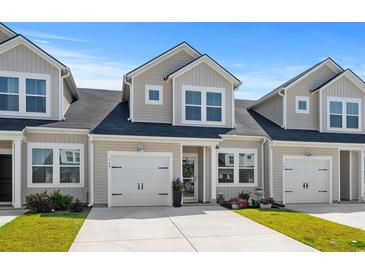 Charming townhome featuring a one-car garage, well-maintained lawn, and neutral color palette at 563 Sea Sparrow St. # 563, Myrtle Beach, SC 29588