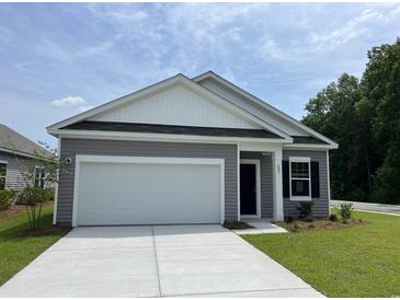 Charming single-story home with gray siding, a two-car garage, and a well-manicured lawn at 602 Muster Field Ct., Conway, SC 29526