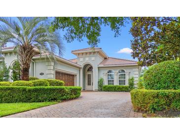 Charming home featuring an elegant facade, arched entryway, manicured hedges and a neatly paved driveway at 7545 Ventura Ct., Myrtle Beach, SC 29572