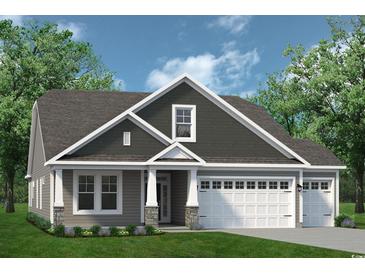 Charming home with a two-car garage, stone accents, a covered entrance, and lush green landscaping at 1571 Breakwater Dr., Little River, SC 29566