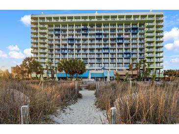 Expansive condominium exterior on a beautiful sunny day with tropical vegetation and sandy beach access at 1105 S Ocean Blvd. # 250, Myrtle Beach, SC 29577