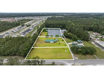 Stunning aerial view of a home with a pond, mature trees, and large lot at 1342 Highway 90, Conway, SC 29526