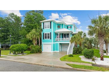 Charming two-story home with a vibrant turquoise exterior, a white roof, and a well-manicured lawn at 17 Trigger Fish Ln., Murrells Inlet, SC 29576