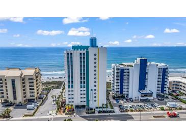 Oceanfront condo building featuring modern architecture, lush landscaping, and stunning ocean views on a clear day at 2301 S Ocean Blvd. # 702, North Myrtle Beach, SC 29582