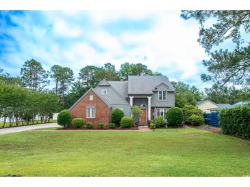 Charming two-story home with a brick facade and lush landscaping at 302 Sunnehanna Dr., Myrtle Beach, SC 29588
