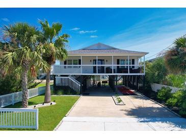 Inviting elevated beach house featuring a covered parking area and beautifully landscaped front yard at 312 35Th Ave. N, North Myrtle Beach, SC 29582