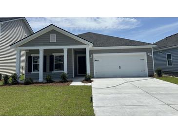Charming single-story home with a two-car garage, manicured lawn, and inviting entrance at 3333 Sw Wood Stork Dr., Ocean Isle Beach, NC 28469