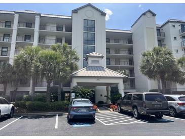 Elegant multi-story building with lush landscaping, covered entrance, and ample parking space at 371 S Dunes Dr., Pawleys Island, SC 29585