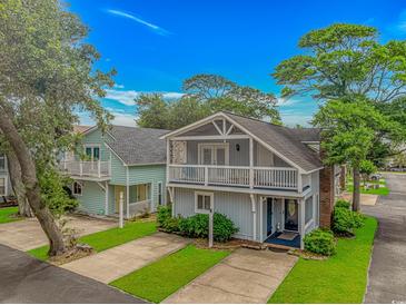 Charming coastal home featuring double balconies, lush landscaping, and a well-maintained lawn at 4309 Beverly Ct., North Myrtle Beach, SC 29582