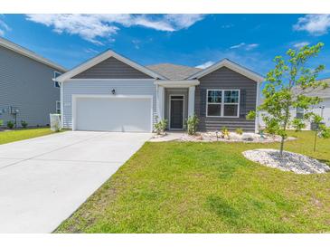 Charming single-story home with a two-car garage and well-manicured lawn and landscaped front yard at 506 Hogwart Ln., Longs, SC 29568