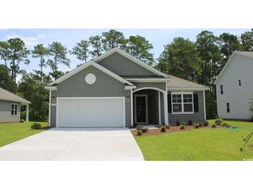 Charming one-story home features a landscaped yard, gray siding, and a two-car garage at 733 Doonbeg Ct., Conway, SC 29526