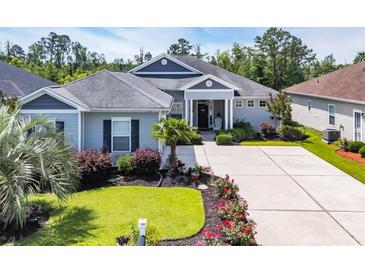 Beautiful single-story home with well-manicured lawn and garden beds, plus an ample driveway and welcoming entryway at 773 Wintercreeper Dr., Longs, SC 29568