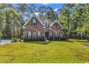 Charming brick home with a well-manicured lawn and lush landscaping, exuding curb appeal at 904 Moultrie Circle, Myrtle Beach, SC 29588