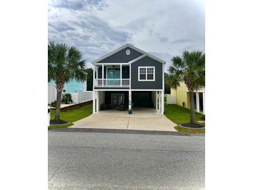 Stunning raised beach home featuring a covered porch, ample parking, and beautiful landscaping at 1961 24Th Ave. N, North Myrtle Beach, SC 29582