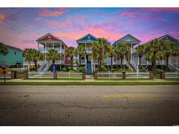 Charming colorful homes with white picket fences, palm trees, and stairs leading to covered porches at 22 Ocean Blvd. N, Surfside Beach, SC 29575