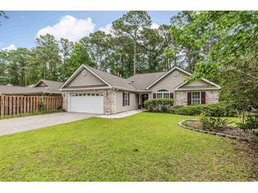 Charming home with well-manicured lawn, brick accents, attached garage, and lush landscaping at 24 Gate 7, Carolina Shores, NC 28467