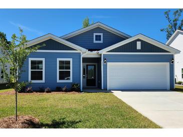 Charming single-story home featuring a blue exterior, manicured lawn, and attached two-car garage at 261 Bolsin Ct, Conway, SC 29526