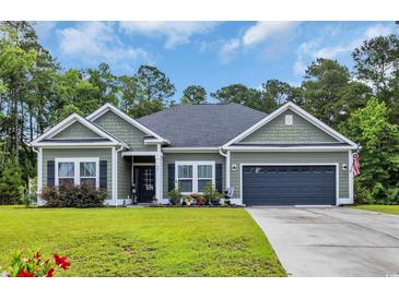 Charming single-story home with green siding, neat landscaping, and a two-car attached garage at 321 Sanctuary Ct., Myrtle Beach, SC 29588
