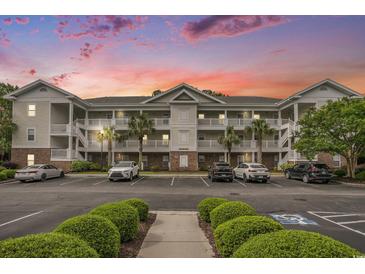 Three-story condo with white balconies, palm trees, and well-maintained landscaping against a vibrant sunset sky at 6015 Catalina Dr. # 634, North Myrtle Beach, SC 29582