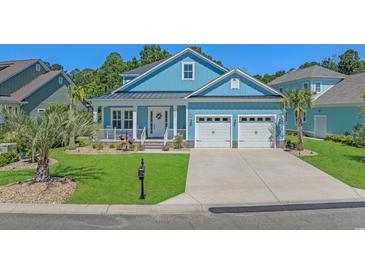Charming blue home with white trim, a well-manicured lawn, and an attached two-car garage at 945 Waterbridge Blvd., Myrtle Beach, SC 29579