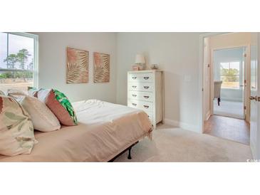 Bright bedroom featuring soft carpet, neutral walls, large window, and a stylish white dresser for ample storage at 9734 Indigo Creek Blvd., Murrells Inlet, SC 29576