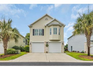 Charming two-story home with double garage and tropical landscaping in a sunny neighborhood at 1413 Cottage Cove Circle, North Myrtle Beach, SC 29582