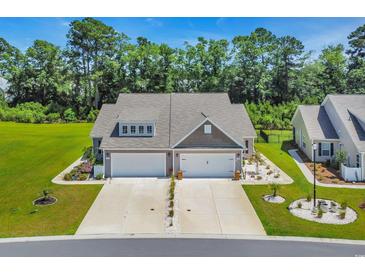 Charming home with two-car garages, a landscaped front yard, and a well-manicured lawn at 1520 Jardine Loop, Little River, SC 29566