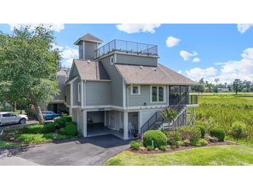 Beautiful two-story home with a rooftop deck, ground floor parking, and landscaped front yard at 1663 Harbor Dr., North Myrtle Beach, SC 29582