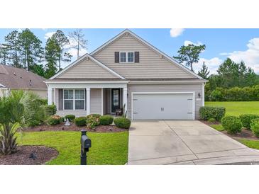 Charming single-story home featuring a well-manicured lawn, a two-car garage, and a welcoming front porch at 308 Firenze Loop, Myrtle Beach, SC 29579