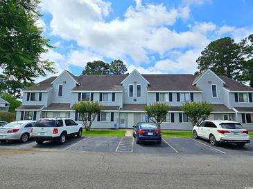 Light gray townhome with well-maintained lawn, parking, and inviting curb appeal on a partly cloudy day at 500 Fairway Village Dr. # 9-K, Myrtle Beach, SC 29588