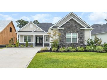Charming single-story home featuring stone accents, manicured lawn, and a welcoming front porch at 1024 Pochard Dr., Conway, SC 29526