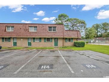 Charming brick condo with green shutters, a red roof, and parking spaces available for residents at 1025 Carolina Rd. # H4, Conway, SC 29526