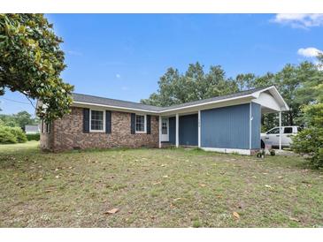 Charming single-story home featuring a brick facade and a covered carport, set on a spacious lot at 169 Ole Maple St., Loris, SC 29569
