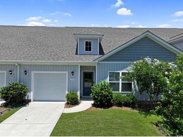 Charming single-story home featuring a well-manicured lawn, attached garage, and inviting front entrance at 184 Sea Shell Dr. # 12, Murrells Inlet, SC 29576