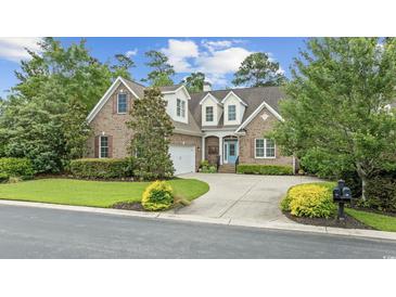 Charming brick home with manicured lawn, mature trees, and welcoming blue front door at 28 Grey Moss Rd., Murrells Inlet, SC 29576