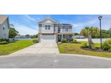 Two-story home featuring gray siding, stone accents, and a well-manicured front yard at 356 Ocean Commons Dr., Surfside Beach, SC 29575
