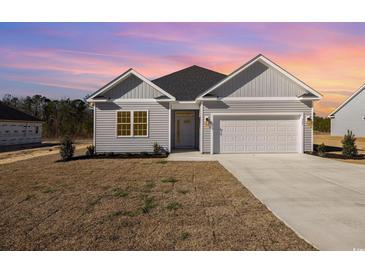 Charming home featuring a two-car garage, and manicured lawn at 369 Log Cabin Rd., Loris, SC 29569