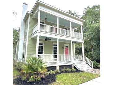 Charming two-story home featuring a double porch, white columns, and a vibrant pink front door at 55 Pineberry Dr., Georgetown, SC 29440