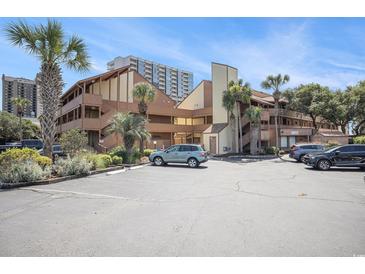 Coastal condo building with palm trees, ample parking, and tan wood siding at 5505 N Ocean Blvd. # 303, Myrtle Beach, SC 29577