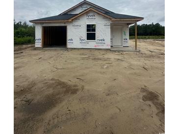 New construction home featuring attached garage and covered entrance, set in a partially cleared lot at 5733 S Highway 41, Marion, SC 29571