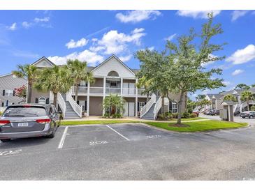 Inviting condominium exterior featuring a two-story design with charming balconies and well-maintained landscaping at 876 Palmetto Trail # 103, Myrtle Beach, SC 29577