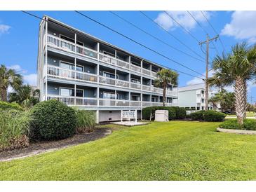 Charming multifamily unit featuring multiple balconies with white railings and lush landscaping at 1210 N Ocean Blvd. # 104, Surfside Beach, SC 29575