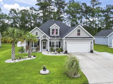 Charming home featuring manicured lawn, palm trees, rock garden, and an attached two-car garage at 144 Baylee Circle, Aynor, SC 29544